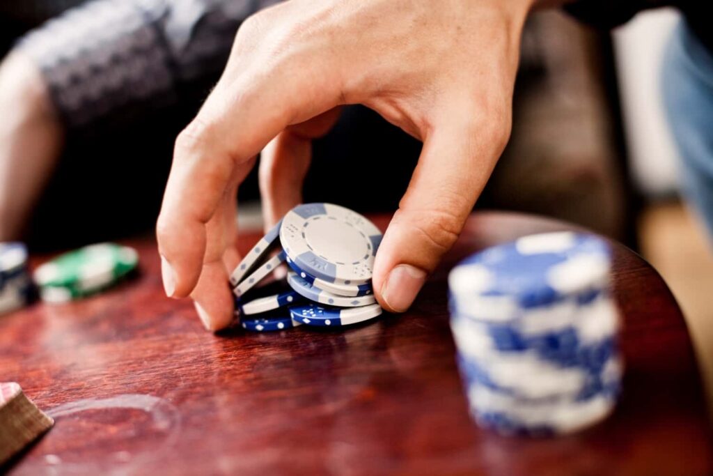 Hand holding poker chips at Castillo Casino